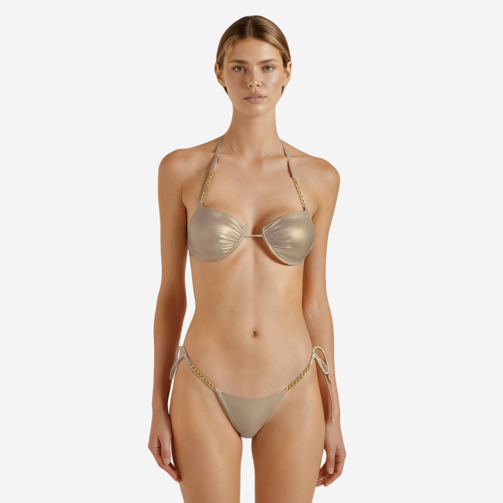 Model wearing metallic gold halter bikini top with ruched cups and chain detailing, paired with matching high-cut bottom featuring side ties and gold chain trim.