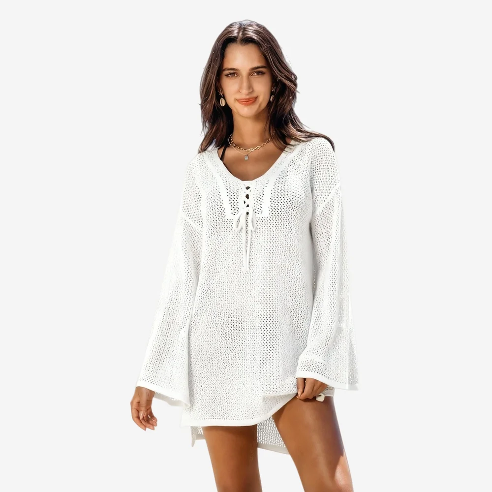 White open-knit beach cover-up tunic with V-neck, lace-up front, and bell sleeves, modeled by woman against white background.