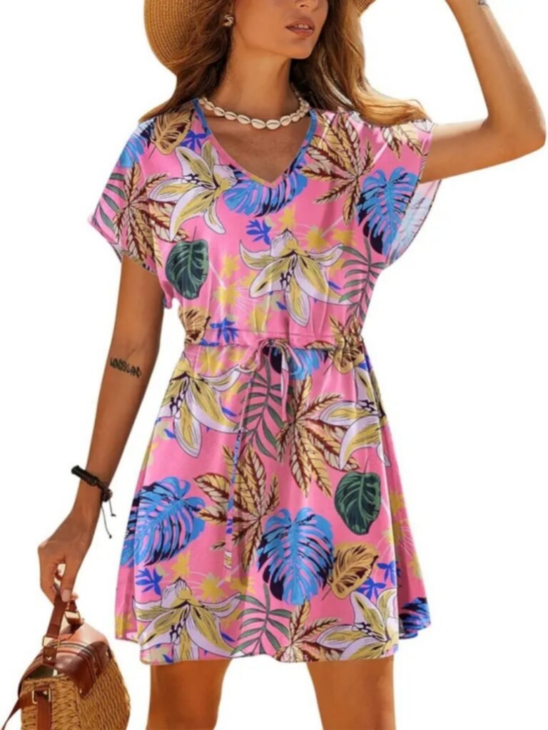 Pink tropical print V-neck short-sleeve dress with leaf and flower pattern, drawstring waist, model holding woven bag.