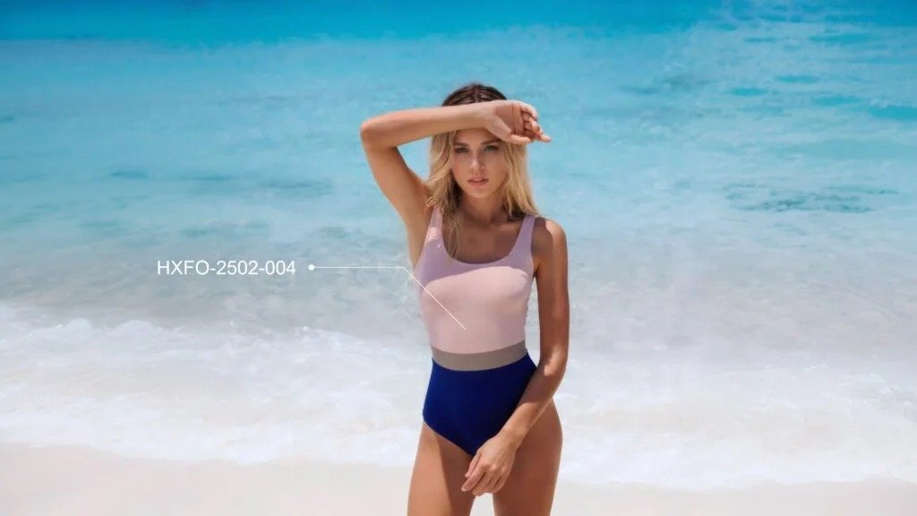 Pink and blue colorblock one-piece swimsuit with square neckline and high-waisted cut, model on beach, product code HXFO-2502-004.