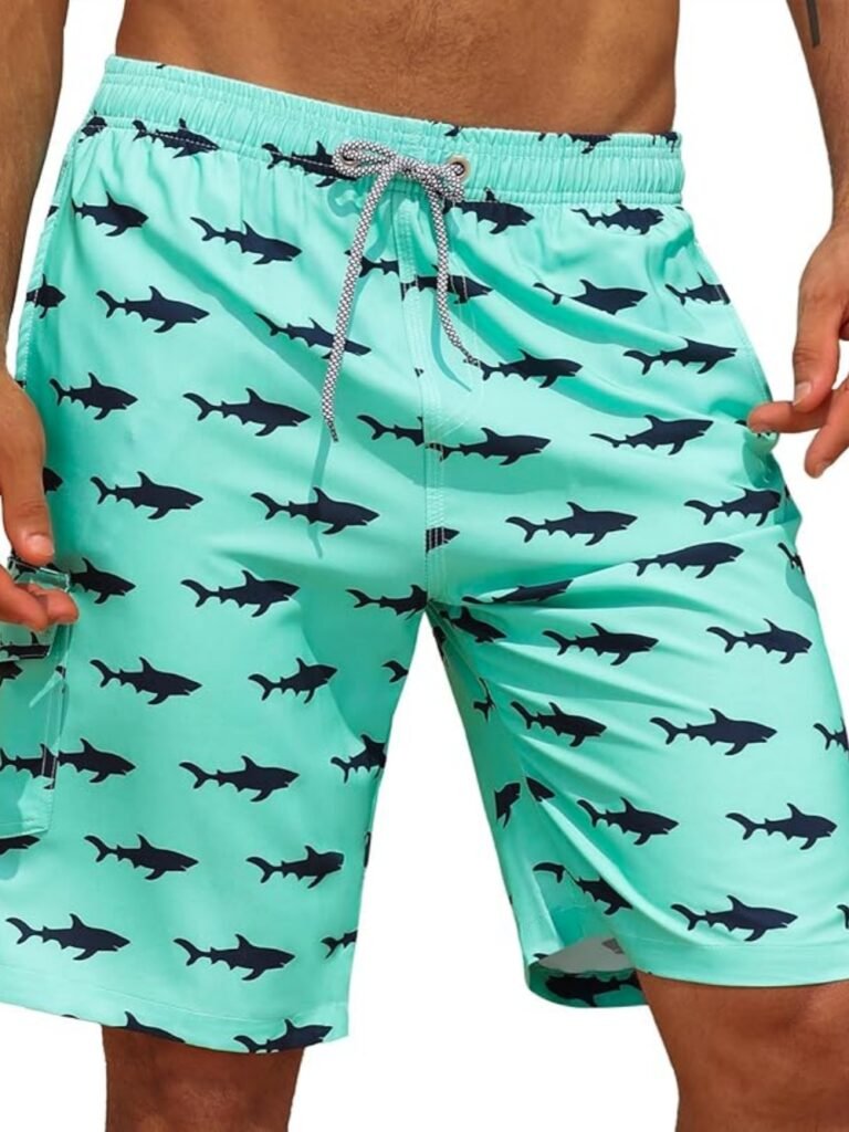 Mint green shark-print swim trunks with black shark pattern, elastic waistband, and drawstring for men’s swimwear.