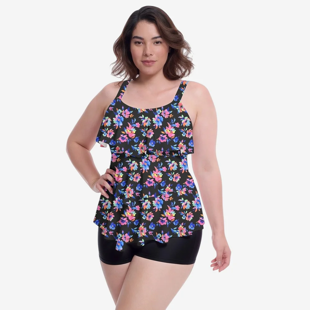 Black floral ruffle tank top with colorful pink/blue flowers, paired with black swim shorts, showcasing plus-size swimwear design.