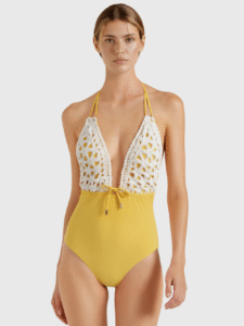 Yellow one-piece swimsuit with white crochet lace overlay, halter straps, and front drawstring waist.
