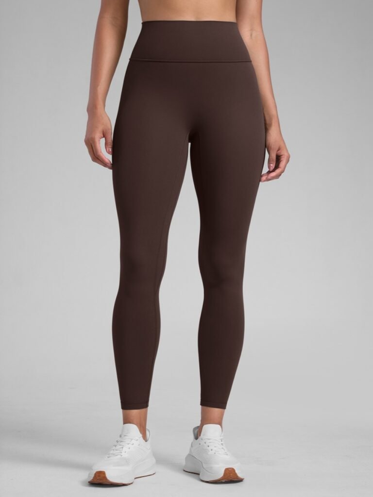 Brown high-waisted seamless leggings on model wearing white sneakers, showcasing form-fitting athletic wear fabric.