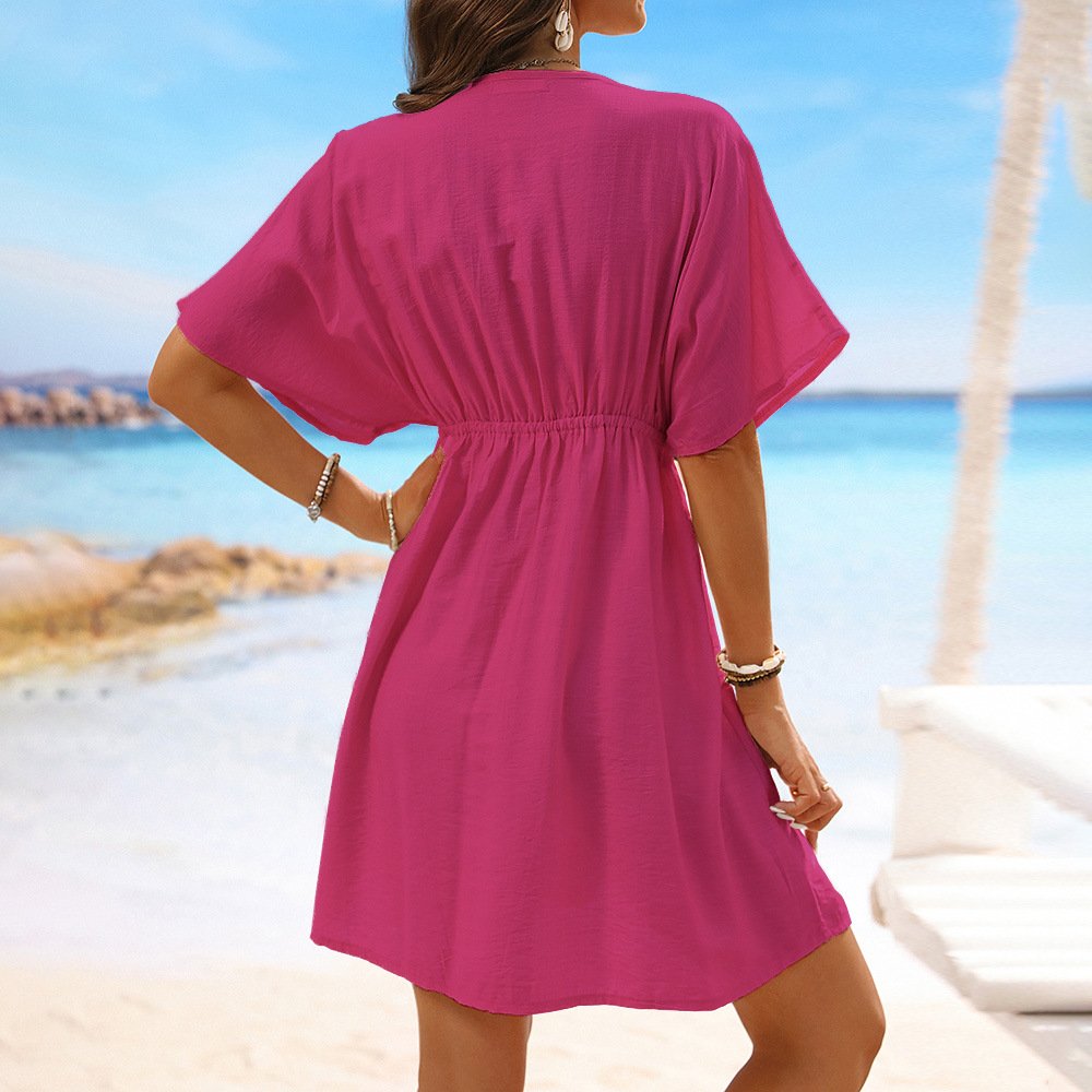Back view of a woman wearing a pink short sleeve kaftan cover-up with an elasticized waist and A-line