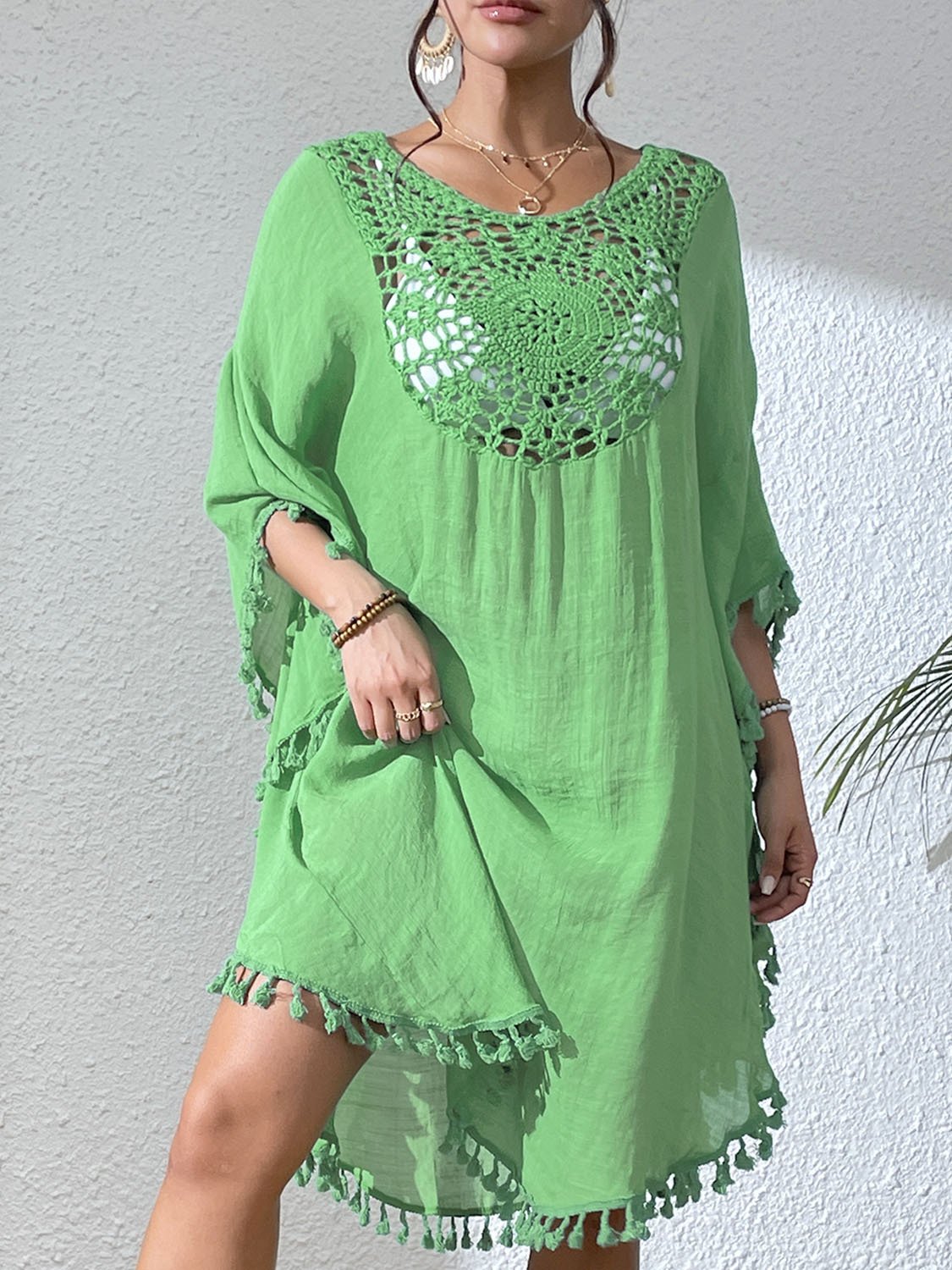 Green loose-fitting kaftan cover-up featuring a crochet yoke neckline and tassel trim along the hem and sleeves.