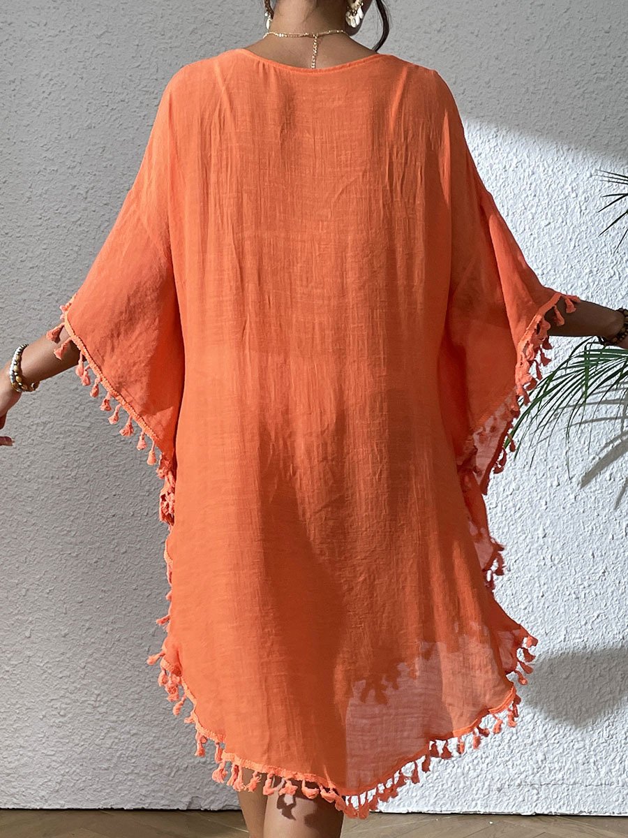 Back view of an orange loose-fitting kaftan cover-up with wide sleeves and tassel trim along the hem and