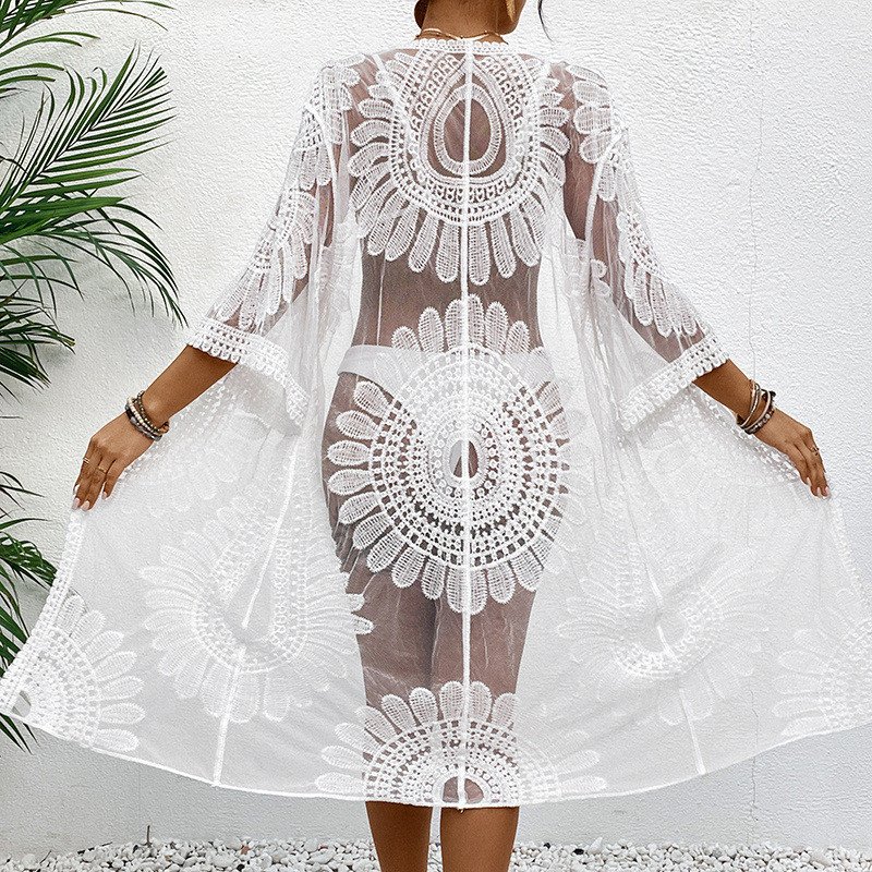White sheer open-front kaftan cover-up with floral cutout details, three-quarter bell sleeves, and scalloped hem.