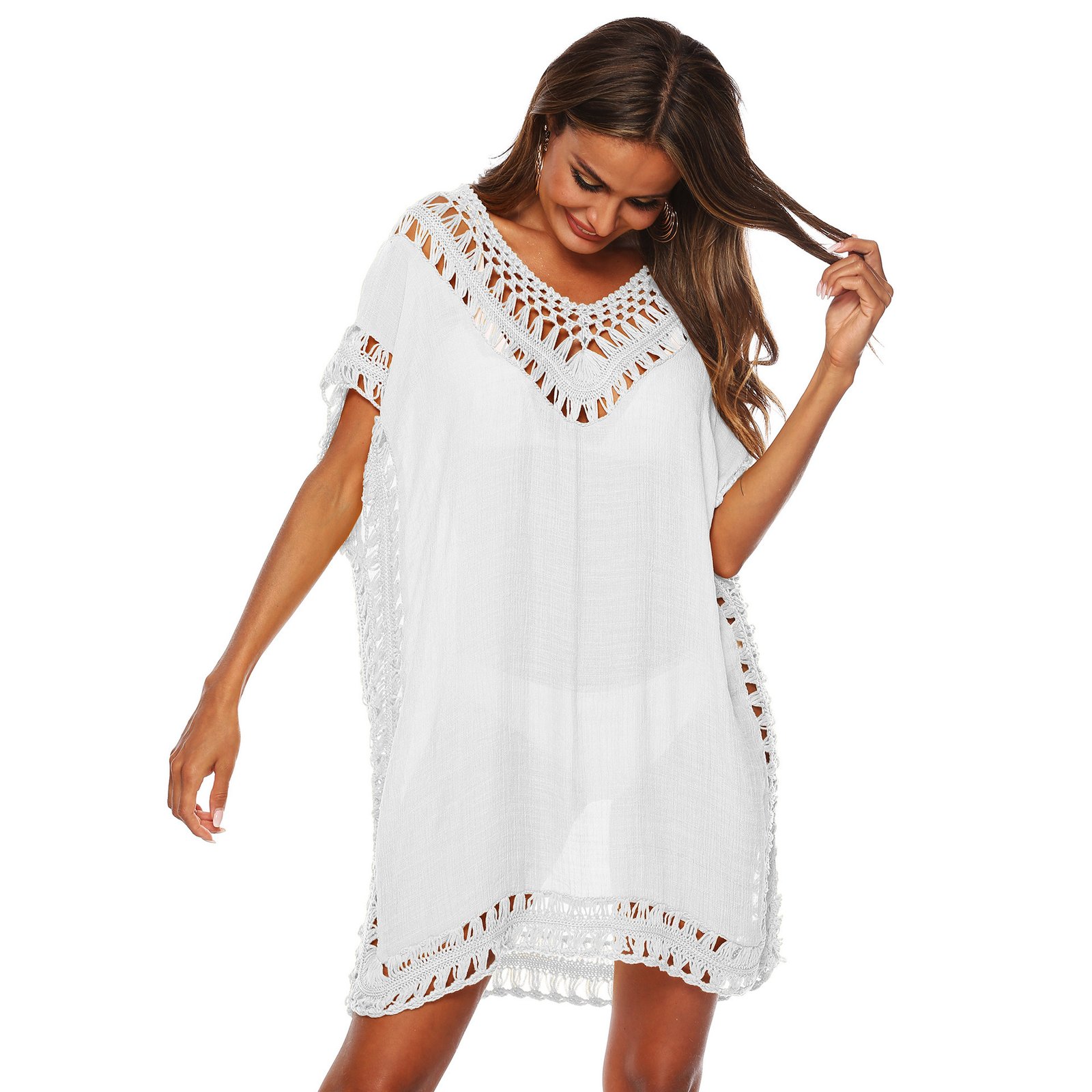 A woman models a white sheer caftan cover-up featuring open-knit crochet trim along the V-neckline, sleeves, and hem.