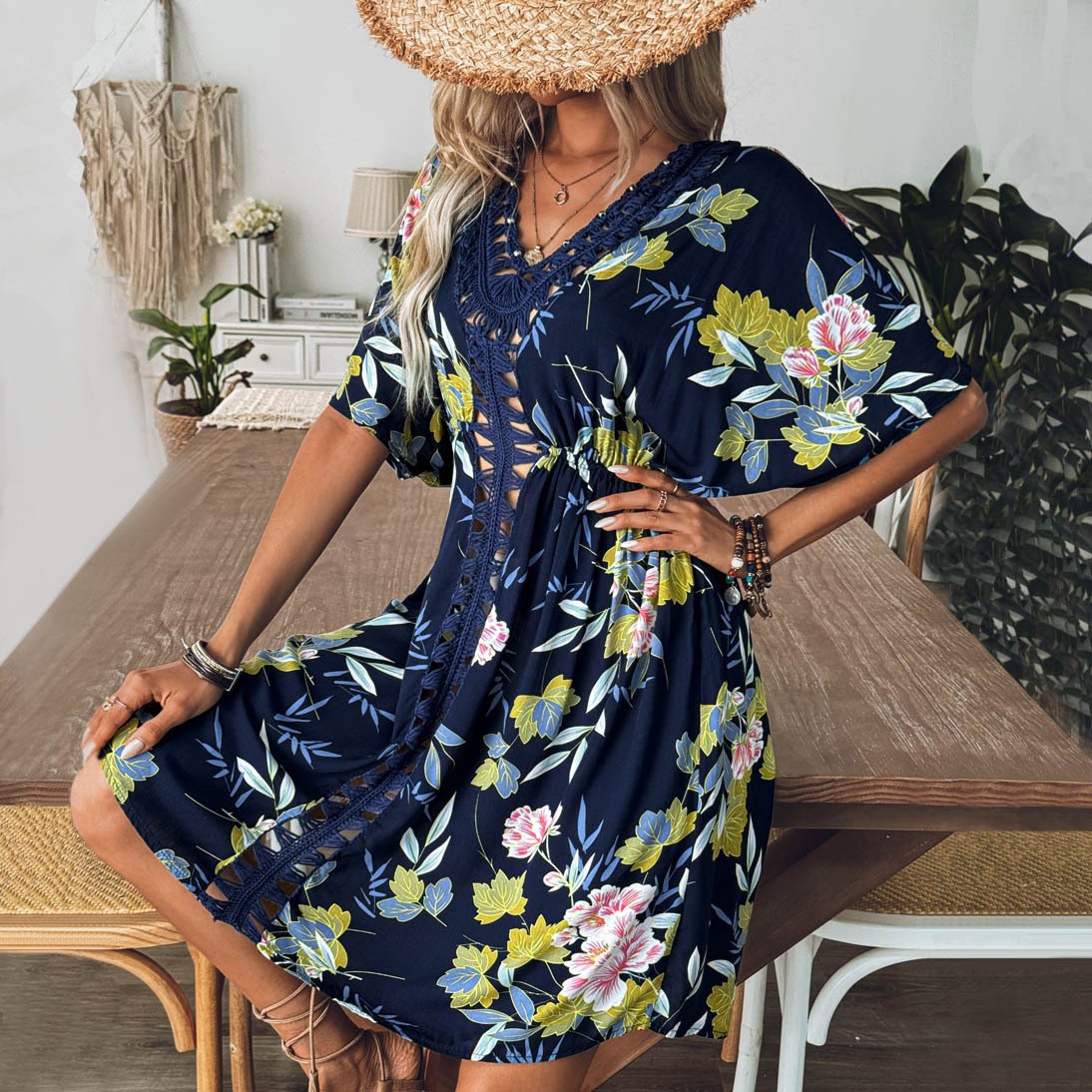 Woman wearing navy floral print V-neck cover-up dress with crochet trim and lace-up front.