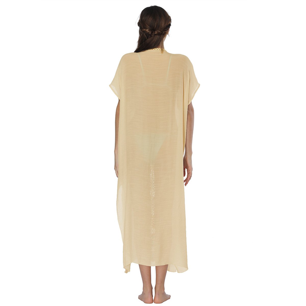 Back view of a woman wearing a loose, beige V-neck caftan cover-up with short sleeves and central crochet