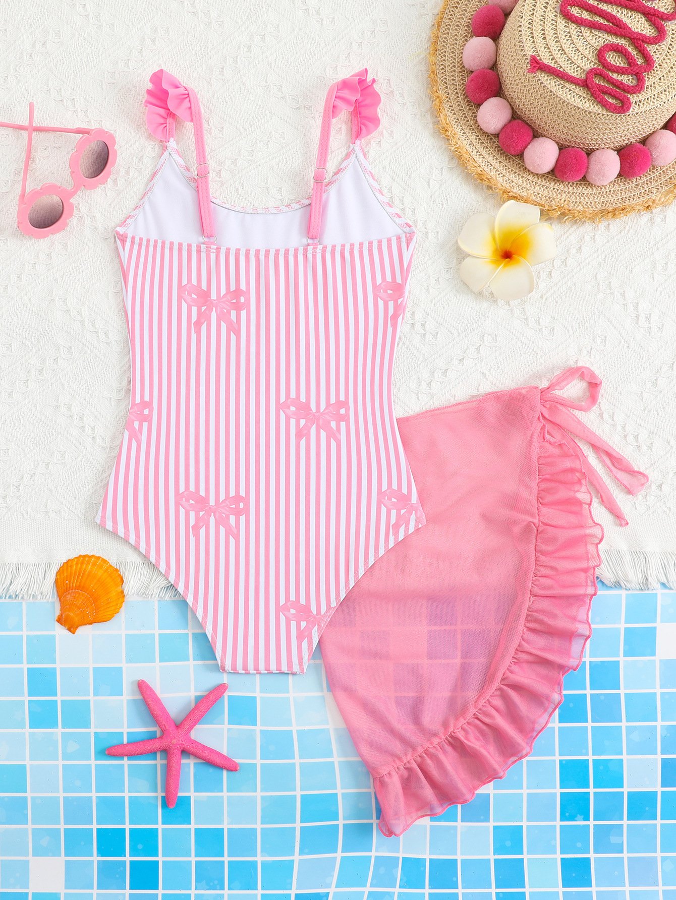 Pink and white striped girls' one-piece swimsuit with ruffled straps and matching ruffled tie skirt.