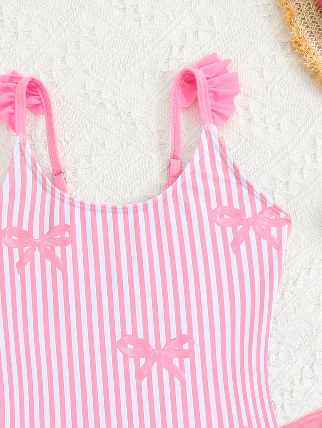 Pink and white vertical striped girls' one-piece swimsuit featuring ruffled shoulder straps and bow details.