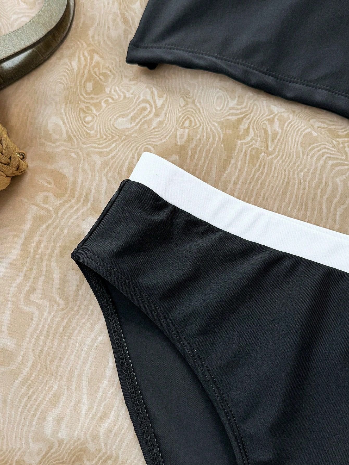 Close-up of a black and white colorblock girls' bikini bottom featuring a contrasting white waistband.