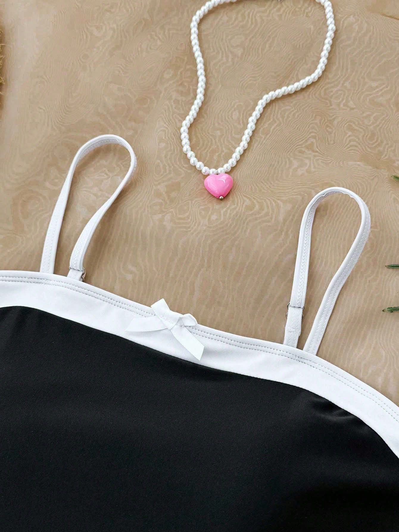 Black and white colorblock girls' tankini top with adjustable spaghetti straps and a small front bow detail.