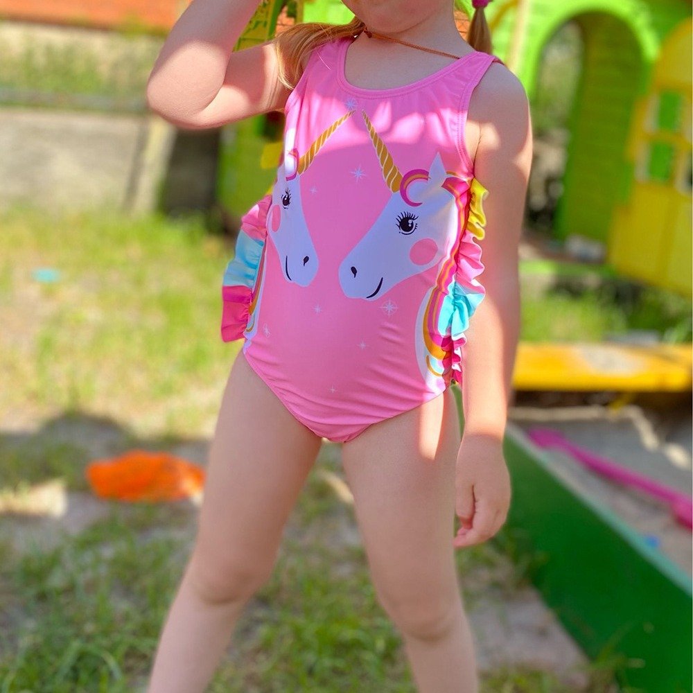 Pink girls' one-piece swimsuit featuring a unicorn print and colorful side ruffles.