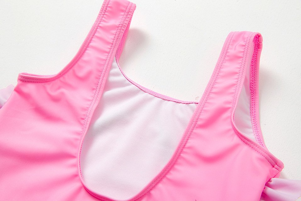 Pink girls' one-piece swimsuit with thick shoulder straps, scoop neckline, and white lining.