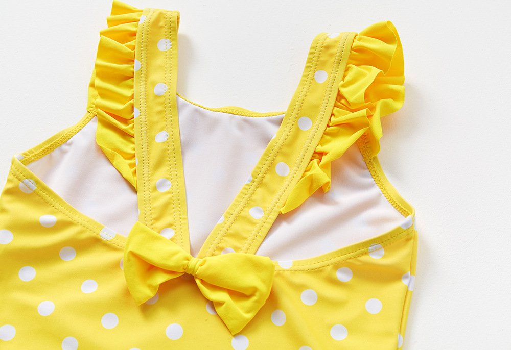 Yellow and white polka dot girls' one-piece swimsuit with ruffled straps and back bow.