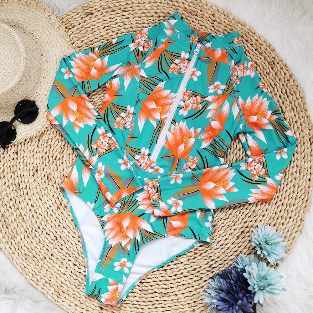 Teal long-sleeve zip-front rash guard one-piece swimsuit with orange floral print and stand collar.