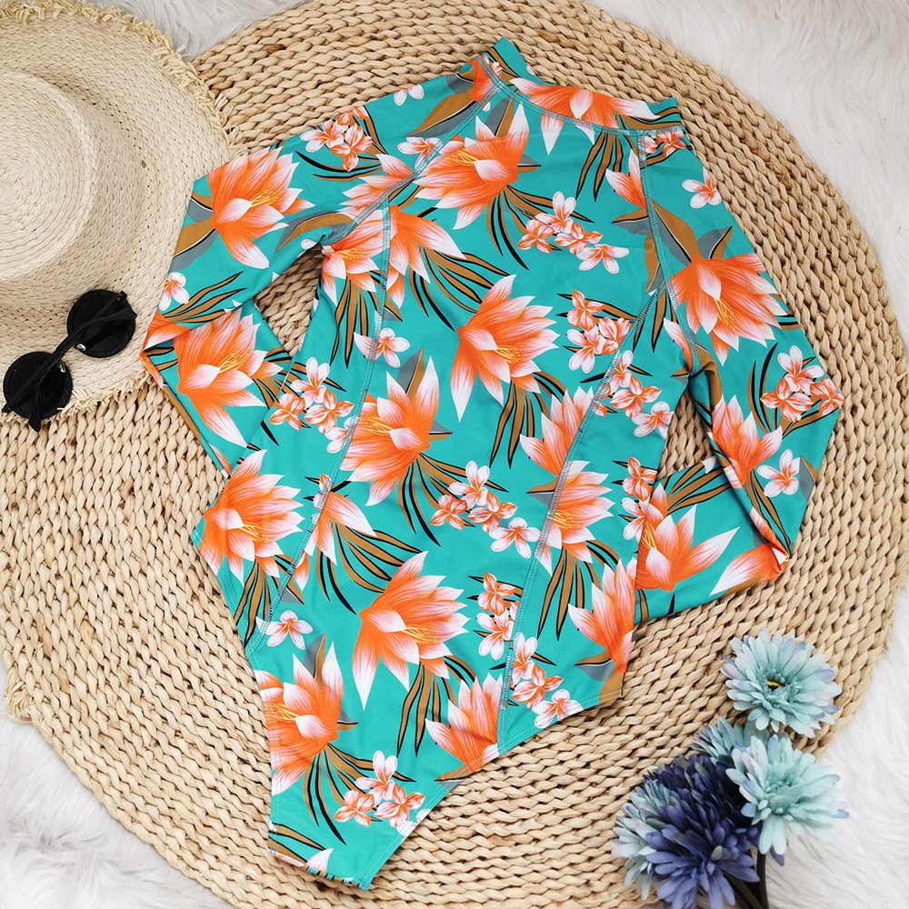 Teal floral long-sleeve one-piece rash guard with front zipper and stand collar.