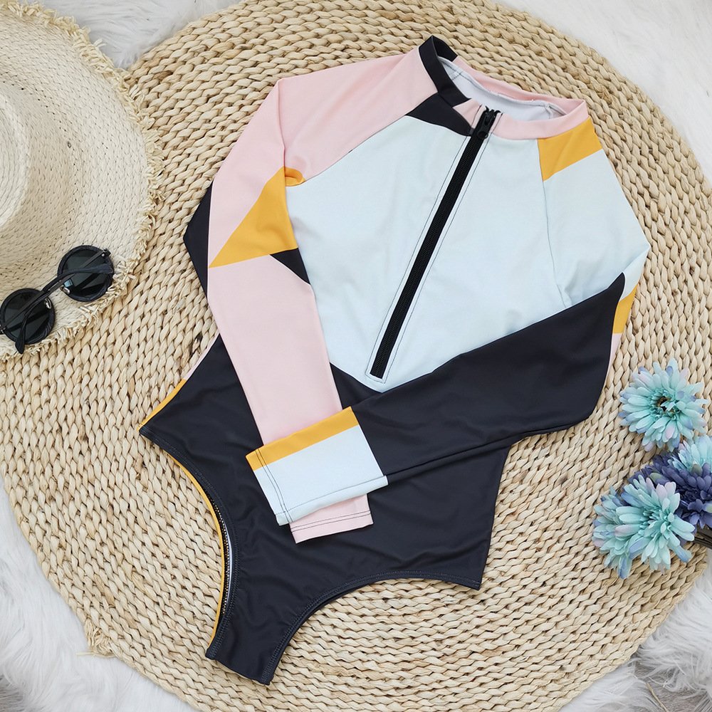Color-block long sleeve zip-front rash guard one-piece in pink, white, yellow, and black.
