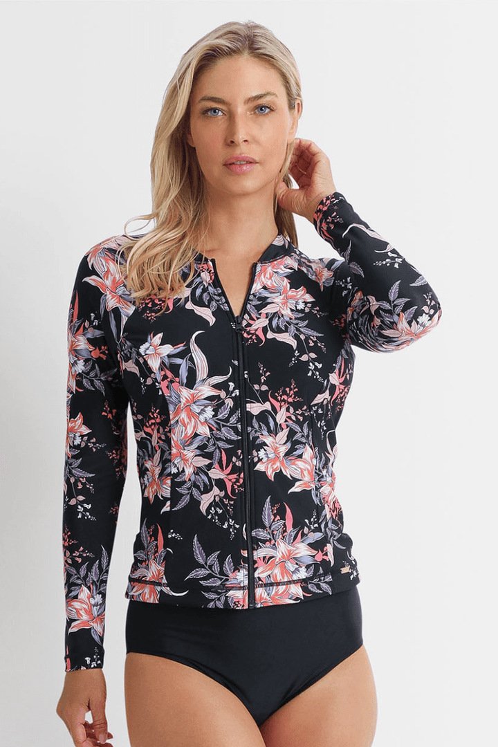 Woman wearing a black long-sleeve zip-front rash guard with pink floral print and high-waisted bikini bottoms.