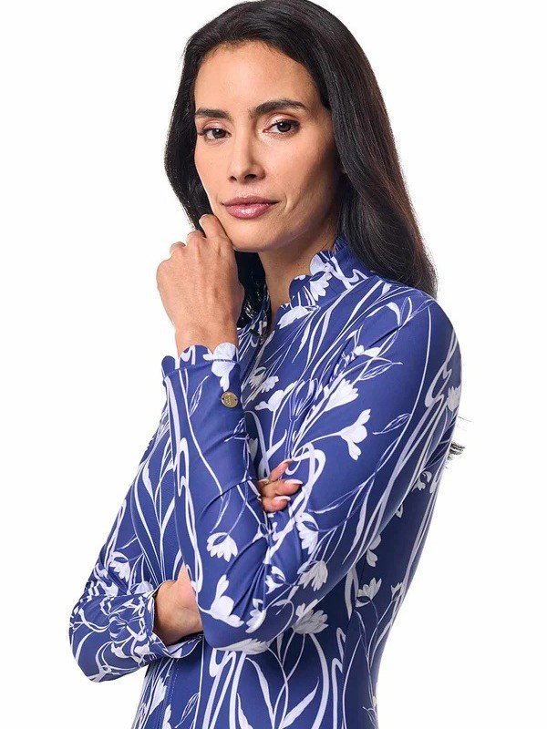 Woman modeling a blue and white floral long-sleeve zip-front rashguard one-piece swimsuit with a stand collar.
