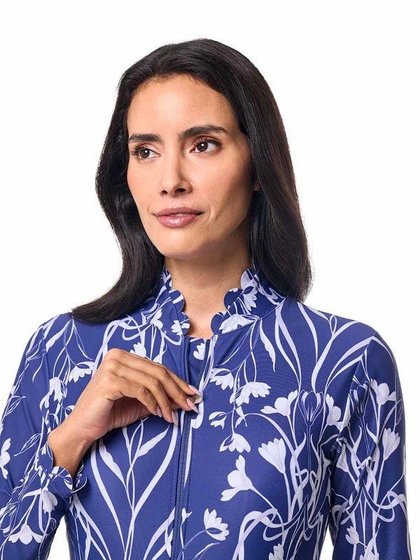 Model wearing a blue and white floral long sleeve zip-front rashguard with a stand collar.