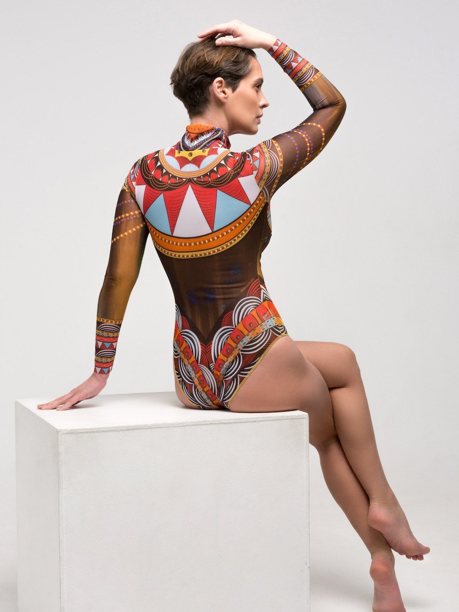 Back view of a model wearing a long sleeve high neck wetsuit with a colorful geometric pattern and