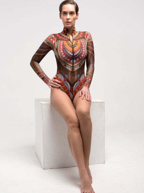 Woman modeling a long sleeve zip-front high neck wetsuit with a colorful geometric print.