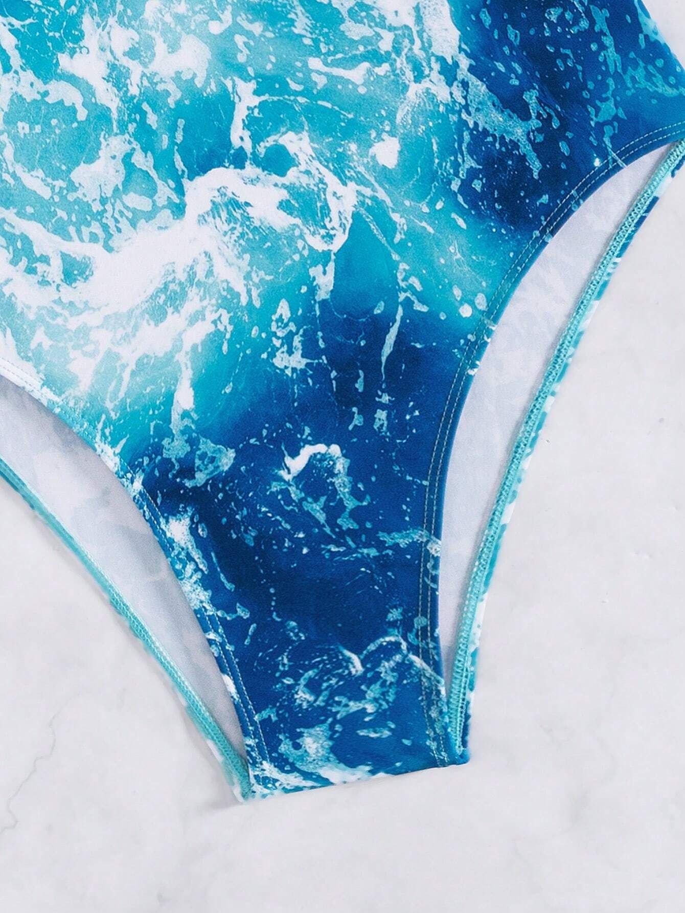 Close-up of a blue and white ocean wave print one-piece swimsuit bottom with high-cut legs.