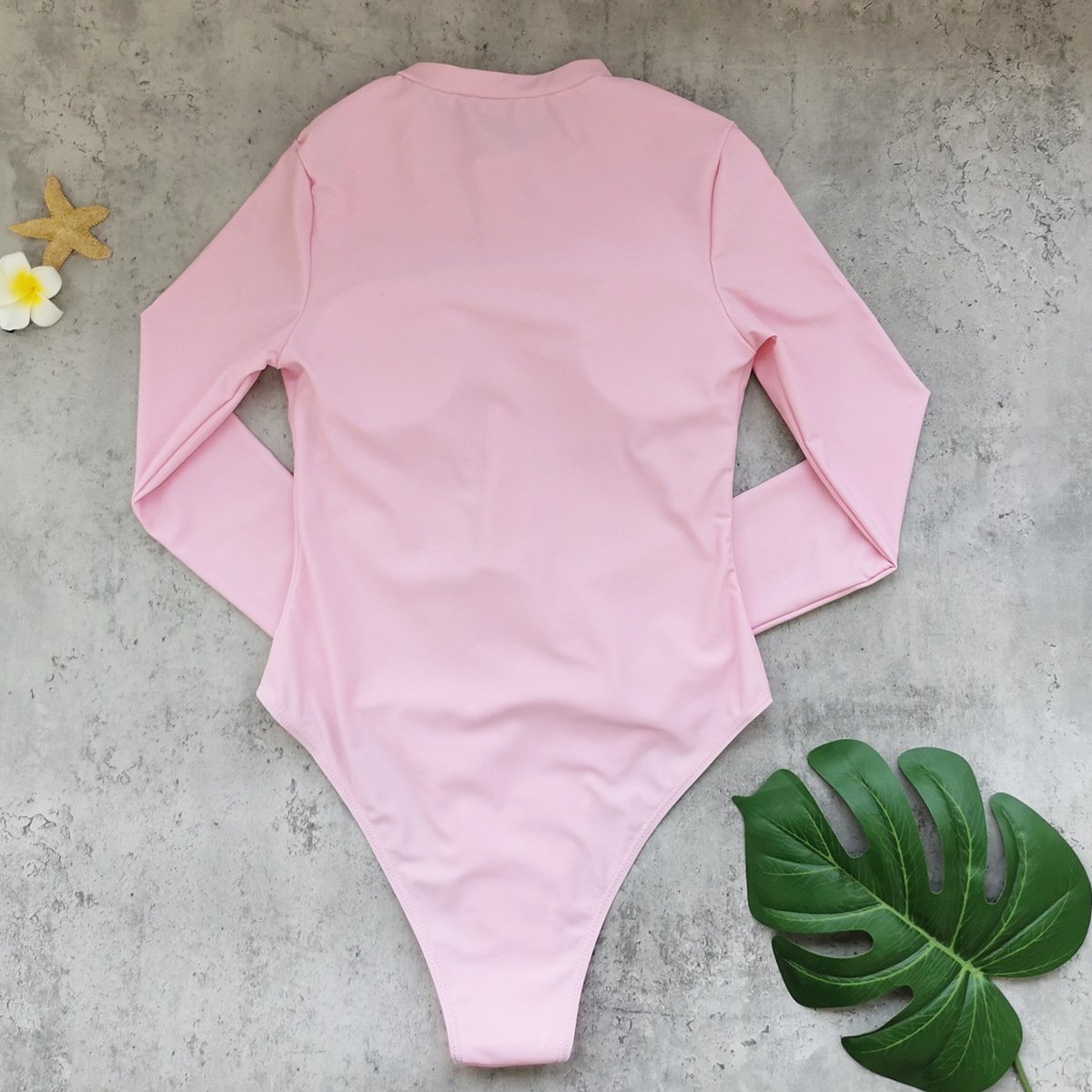 Back view of a pink long-sleeve one-piece swimsuit featuring a high-cut leg design and stand collar.