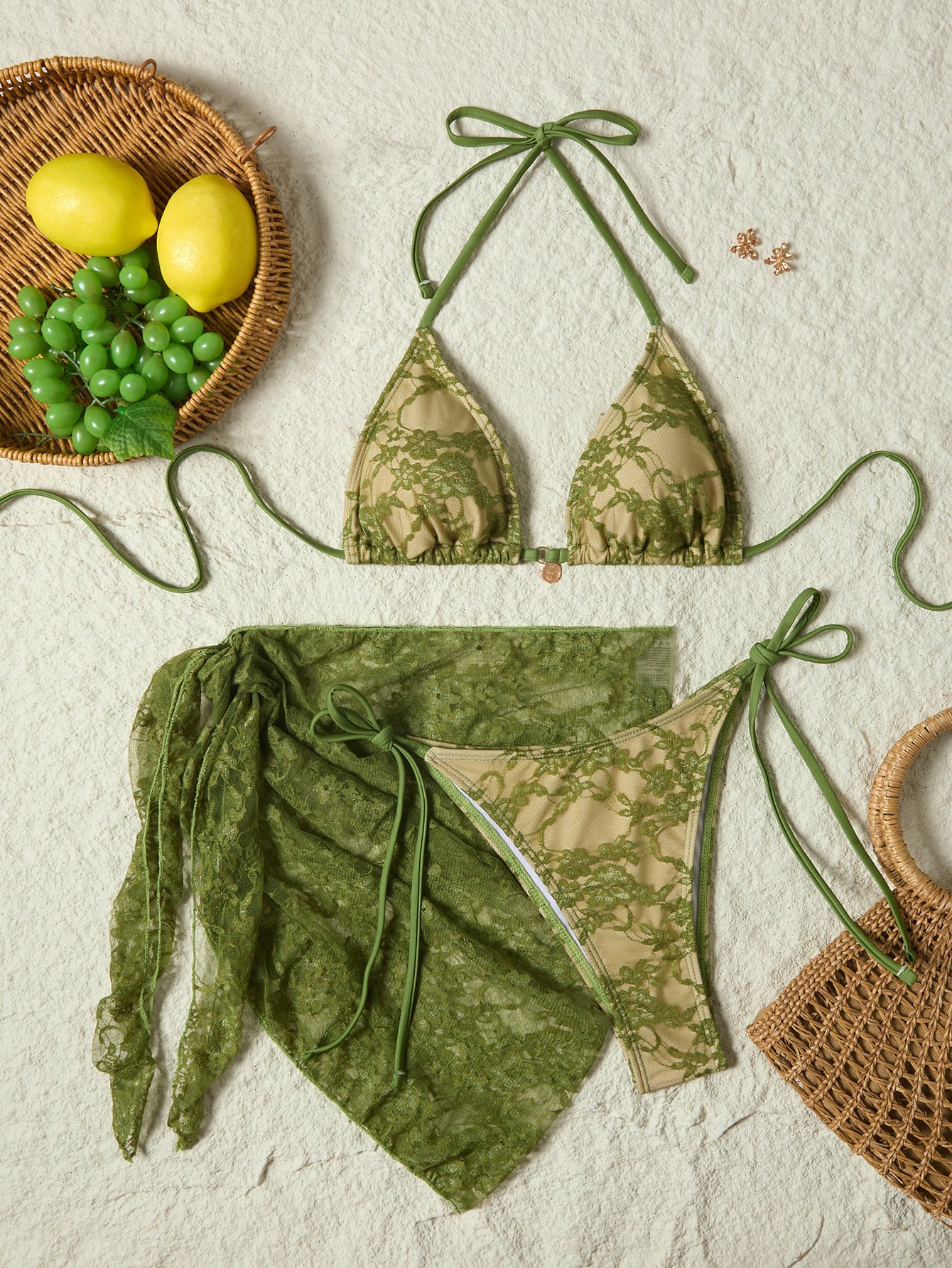 Three-piece green lace bikini set with halter tie top, tie-side bottoms, and matching wrap skirt.