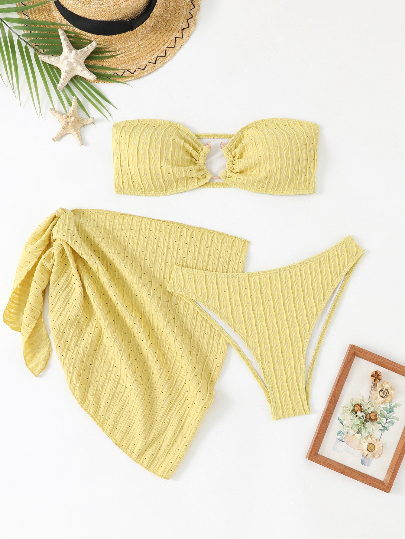 Yellow three-piece swimwear set featuring a ruched bandeau top with center ring, bikini bottoms, and a wrap skirt.