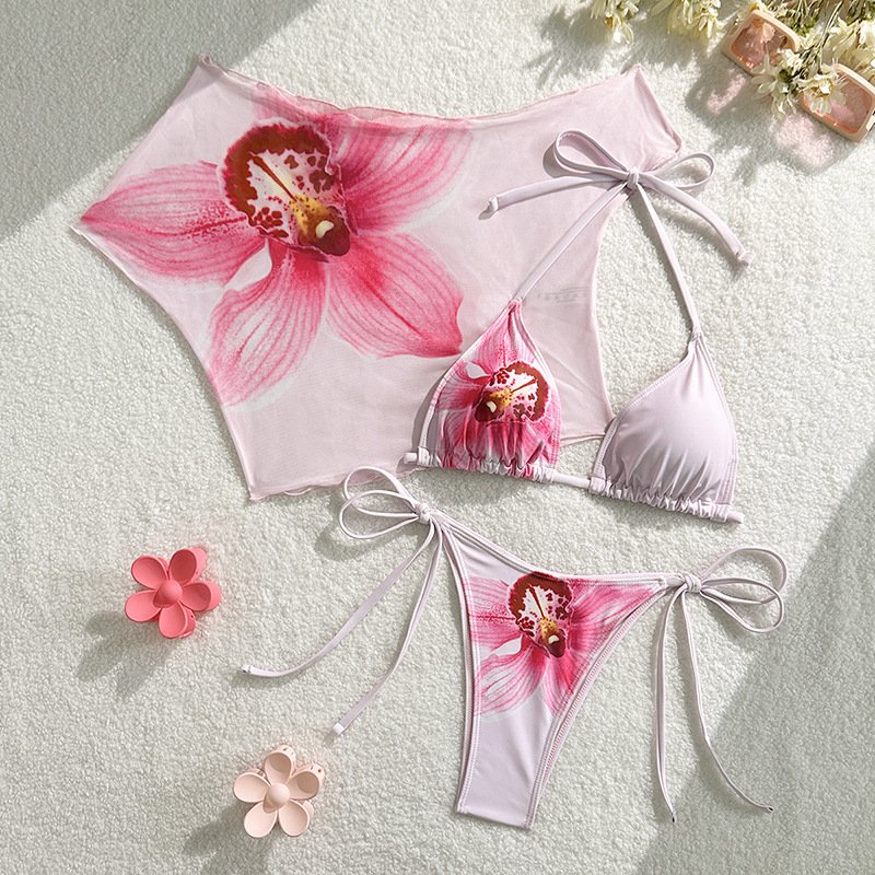 Pink floral print three-piece bikini set with triangle top, side-tie bottoms, and off-shoulder mesh cover-up.