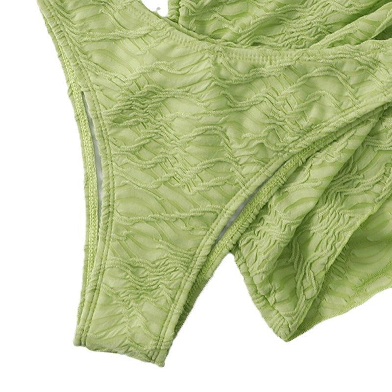 Light green textured two-piece swimwear set featuring a high-waisted wrap skirt and matching bottoms.