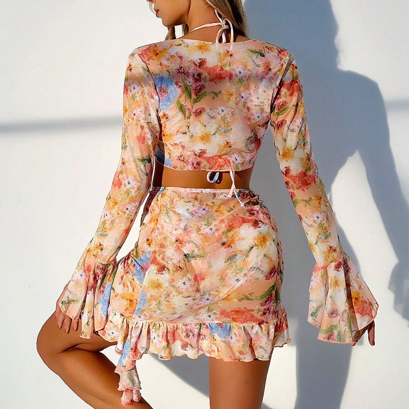 Back view of a floral print two-piece cover-up set featuring a long-sleeve crop top with bell sleeves and