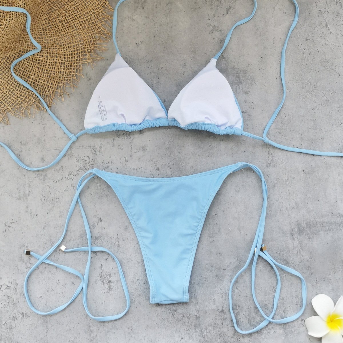 White and light blue two-piece triangle bikini with string ties and ruffled trim.