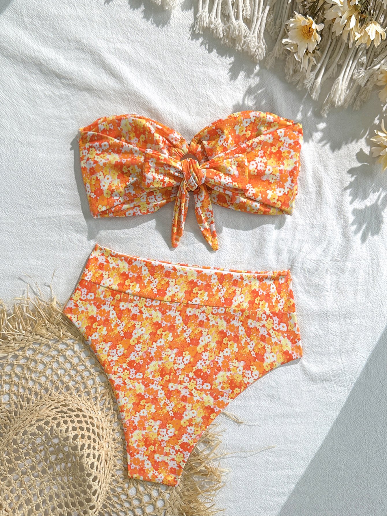 Orange and white floral print bandeau bikini set with a front knot top and high-waisted bottoms.