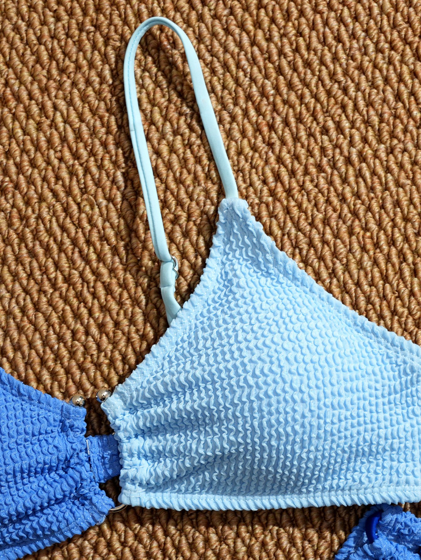 Light blue textured triangle bikini top with adjustable straps and metal hardware.