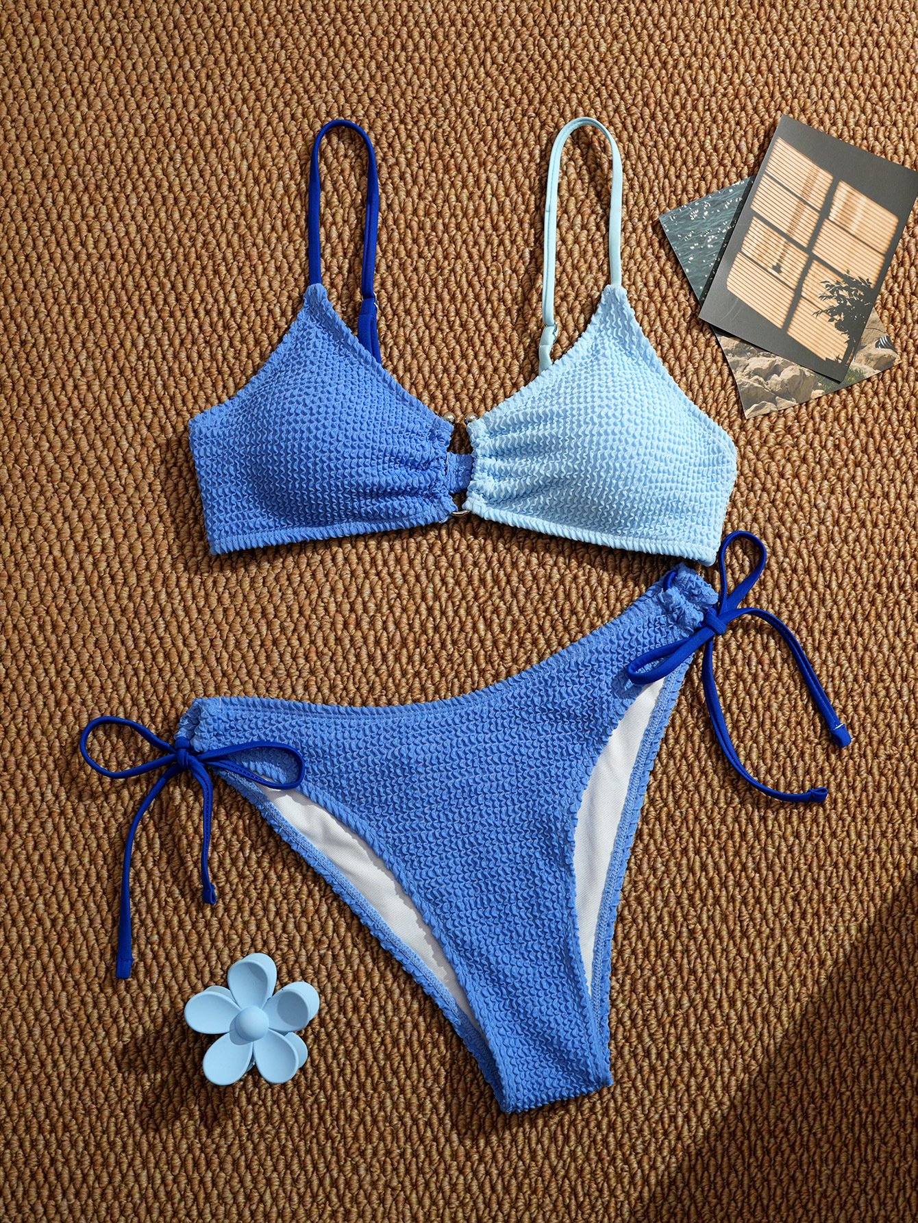 Two-piece textured blue and light blue triangle bikini set with tie-side bottoms.