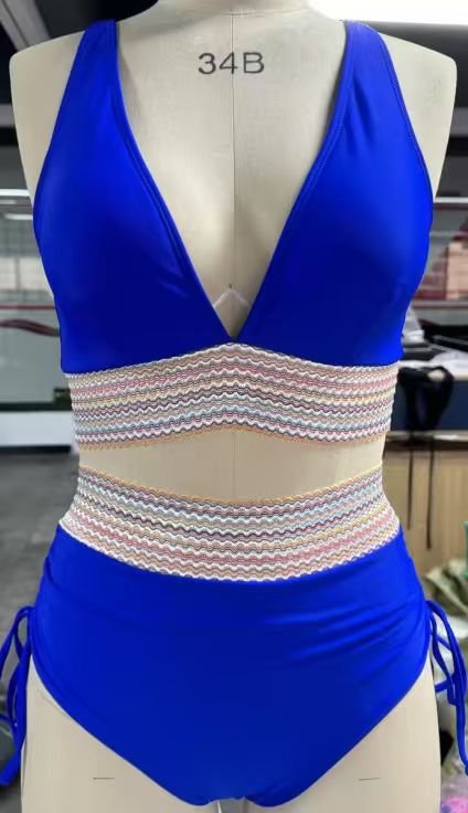 Blue halter crop top and high-waisted bikini set featuring patterned elastic bands and tie-side bottoms.
