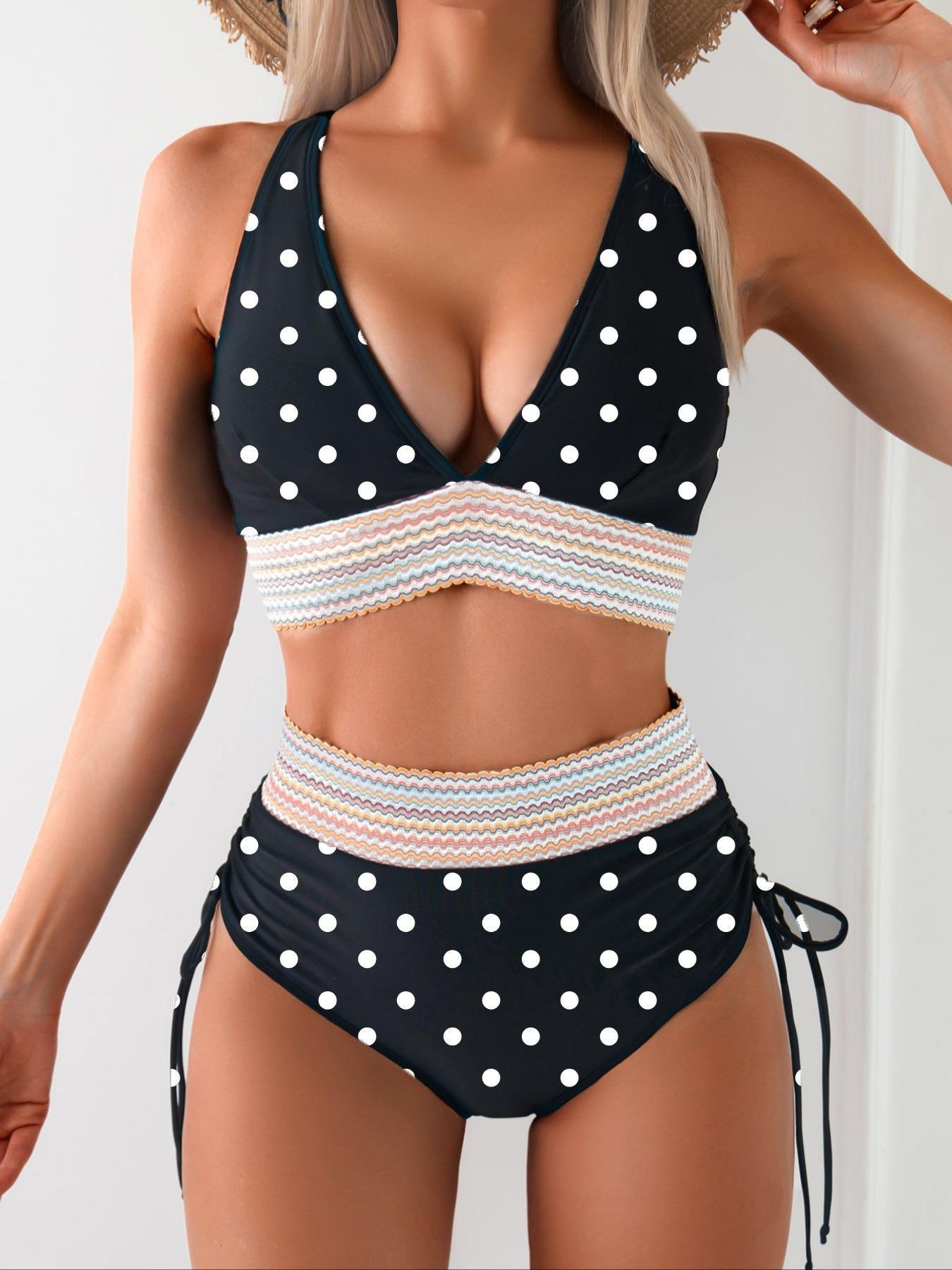 Black and white polka dot halter crop top bikini with colorful striped band and high-waisted ruched tie-side bottoms.