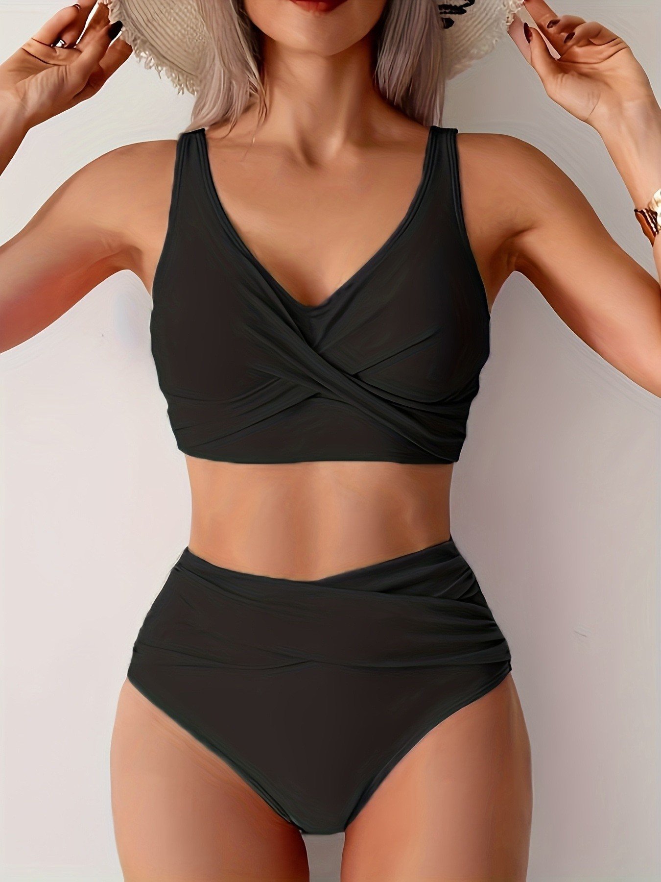 Black two-piece bikini set with a twist-front crop top and high-waist ruched bottoms.