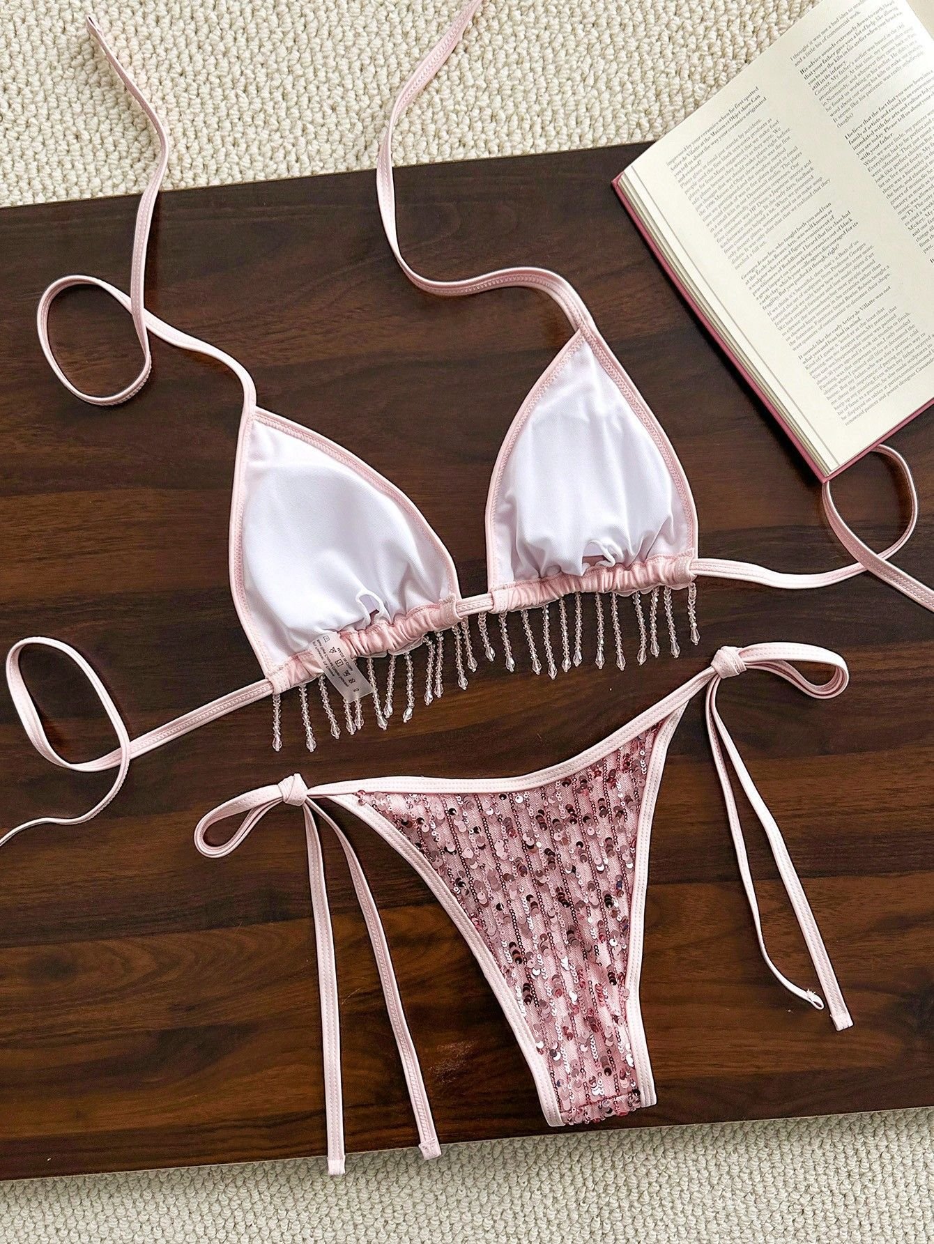 Pink two-piece bikini set featuring a fringe-trim triangle halter top and sequined tie-side bottoms.