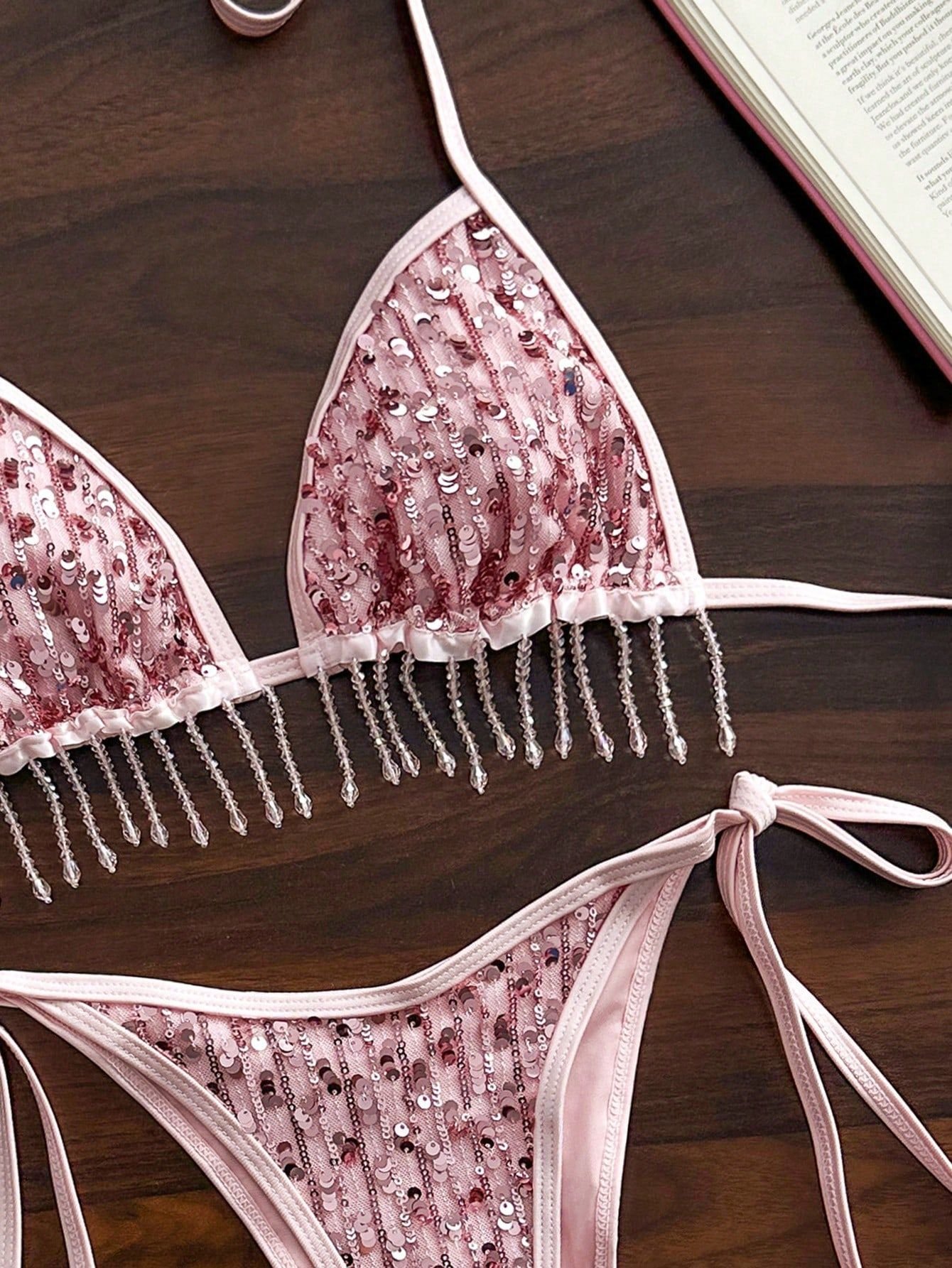 Pink sequined triangle bikini set with halter top, beaded fringe trim, and tie-side bottoms.