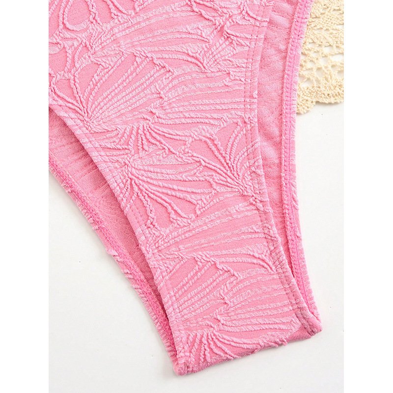Close-up of pink textured bikini bottoms featuring a raised leaf pattern and hemmed edges.
