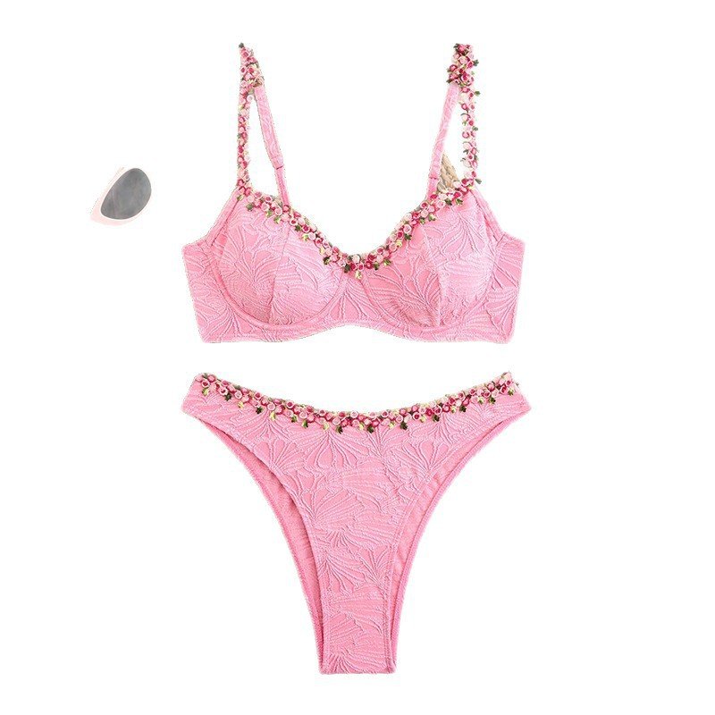 Pink textured two-piece bikini set with underwire bralette top and floral embellishments along the edges.