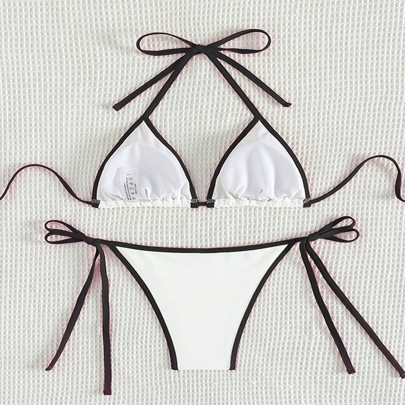 White triangle bikini set with dark contrast piping, halter neck ties, and adjustable side strings.