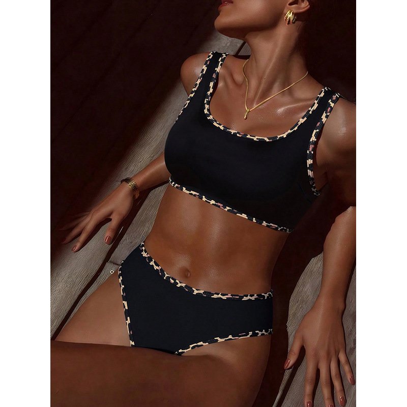 Black two-piece swimwear set featuring a scoop neck tankini top and high-waisted bikini bottom with patterned trim.